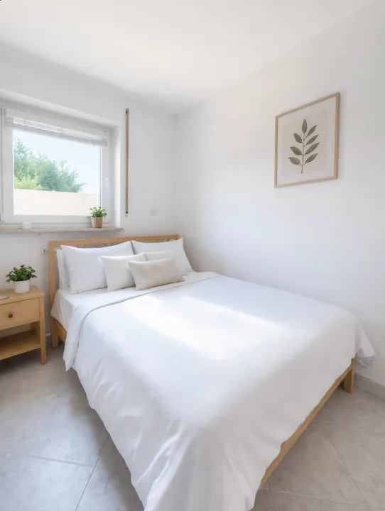 Helles Schlafzimmer mit Doppelbett und Fenster